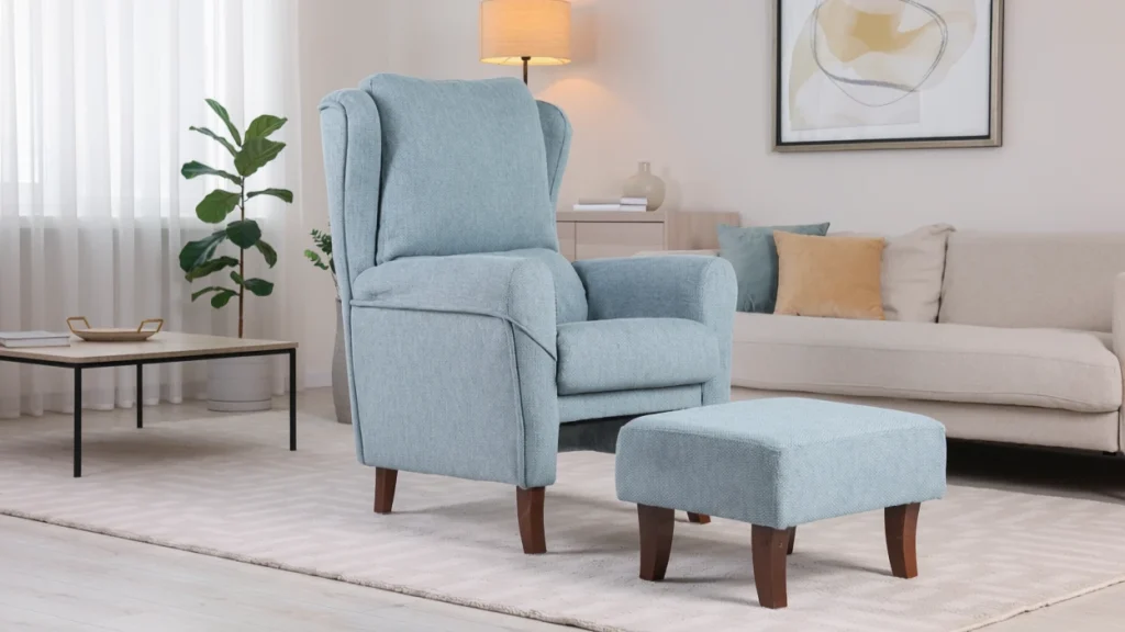 Silla de reclinación azul claro con reposapiés en una sala de estar moderna con sofá beige